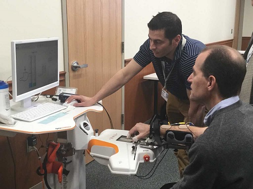 Therapist giving a demonstration of robotic device to a visitor.